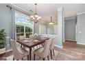 Dining room with a large window, chandelier, and a table set for six with elegant chairs at 6849 Blake Brook Dr, Concord, NC 28025