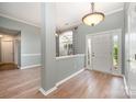 Welcoming foyer with hardwood floors, white trim, a front door with sidelights, and a large window at 6849 Blake Brook Dr, Concord, NC 28025