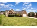 Exterior view of home with brick and siding, an attached two-car garage, and a lush green lawn at 6849 Blake Brook Dr, Concord, NC 28025