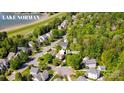 Aerial view of home in a lush, green neighborhood near Lake Norman with mature trees and manicured lawns at 7409 Gilderstern Glen Ct, Huntersville, NC 28078