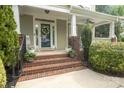 Inviting front porch with brick stairs and wrought iron railings, adorned with plants and a wreath on the door at 7409 Gilderstern Glen Ct, Huntersville, NC 28078