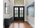 Elegant entryway with glass paneled double doors, hardwood floors, and stylish decor at 767 Pinnacle Dr, Iron Station, NC 28080