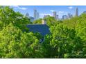 Elegant home nestled among trees, with a glimpse of the city skyline at 974 Queens Rd, Charlotte, NC 28207