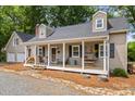 Inviting front porch with seating, wood storage, and classic black and white checkered rug at 10139 Arlington Church Rd, Mint Hill, NC 28227