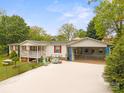 A charming one-story home featuring a fenced yard, white siding, red shutters, and a spacious driveway at 1106 3Rd Sw Ave, Hickory, NC 28602