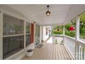 Covered front porch, features white railings, hanging plants, and a view of the charming neighborhood at 1106 3Rd Sw Ave, Hickory, NC 28602