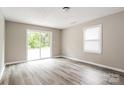Bright bedroom featuring stylish wood-look flooring and a sliding glass door to the backyard at 1204 Glenarden Dr, Rock Hill, SC 29730