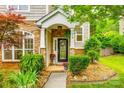 Charming front porch with stone pillars, floral decor, and a welcoming front door at 1418 Lonan Dr, Waxhaw, NC 28173