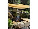 Relaxing koi pond with rock features and a shade covering at 1418 Lonan Dr, Waxhaw, NC 28173