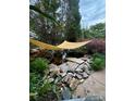 Backyard koi pond featuring rock features, lush greenery, and a shade covering at 1418 Lonan Dr, Waxhaw, NC 28173