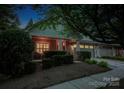 Charming home featuring a beautifully landscaped front yard with mature trees and inviting curb appeal at night at 142 Aztec Cir, Mooresville, NC 28117