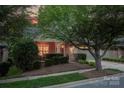 Charming home featuring a beautifully landscaped front yard with mature trees and inviting curb appeal at sunset at 142 Aztec Cir, Mooresville, NC 28117