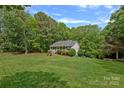 Expansive backyard featuring a well-manicured lawn, mature trees, and charming single-story home at 160 Kingfisher Dr, Mooresville, NC 28117