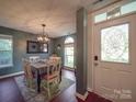 Bright dining area with modern chandelier, wood floors, and a view to the entryway at 1715 Colin Creek Ln, Charlotte, NC 28214