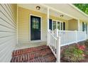 Close-up view of the front entrance showing a brick porch and black front door at 185 Hunters Point Dr, Rockwell, NC 28138