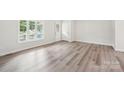 Bright living room with wood-look flooring, neutral paint, and a large window at 185 Hunters Point Dr, Rockwell, NC 28138