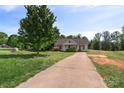 Quaint home with long driveway and well-manicured lawn and garden showcasing simple curb appeal at 244 Whitesides Rd, Bessemer City, NC 28016
