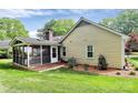 The exterior of the home showcasing a screened in porch, greenery and neutral paint at 2506 Breuster Dr, Charlotte, NC 28210