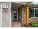 A welcoming front porch with brick columns, a storm door and decorative lighting, showcasing curb appeal at 286 Hemlock Bluff Ct, Denver, NC 28037
