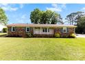 Charming single-story brick home with blue shutters and well-manicured lawn and landscaping at 300 Scotland Dr, Kings Mountain, NC 28086
