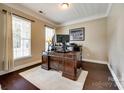 Cozy home office with large wooden desk, neutral walls, and bright natural light from large windows at 4704 Amberside Dr, Rock Hill, SC 29732