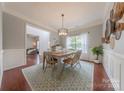 Elegant dining room with hardwood floors, a stylish light fixture, and natural light from the windows at 5707 Parkstone Dr, Matthews, NC 28104