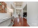 Spacious entryway featuring hardwood floors, a console table, and an open view of the staircase at 5707 Parkstone Dr, Matthews, NC 28104