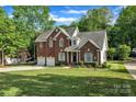 Charming two-story brick home with a well-manicured lawn and an attached two-car garage at 5775 Monticello Nw Dr, Concord, NC 28027