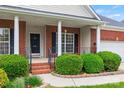Inviting front porch with brick columns and decorative iron railings at 8120 Calistoga Ln, Waxhaw, NC 28173