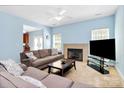 Relaxing living room with a fireplace and comfortable seating under a cooling ceiling fan at 8200 Park Vista Cir, Charlotte, NC 28226