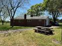 Backyard exterior featuring a stone picnic table, driveway, and garage at 8588 Smith Rd, Kannapolis, NC 28081