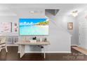 Bright living area showcasing a large television, a staircase, and modern décor at 8814 Gerren Ct, Charlotte, NC 28217