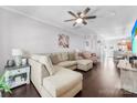 Spacious living room featuring a large sectional sofa, ceiling fan, and wood flooring at 8814 Gerren Ct, Charlotte, NC 28217