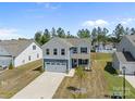 Charming two-story home featuring blue and white siding, a two-car garage, and a manicured front yard at 2022 Mcdonald Dr, Stanfield, NC 28163