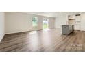 Spacious living room features modern vinyl flooring, large windows, sliding glass doors and a kitchen island with sink at 2106 Columbidae Ln, Gastonia, NC 28052