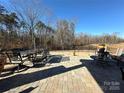 Inviting outdoor patio with dining table, comfortable seating, and a tranquil view of the wooded backyard at 21110 Bank Fire Ln, Huntersville, NC 28078