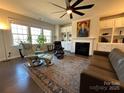 Cozy living room featuring a fireplace, built-in shelving, large windows, and comfortable seating at 21110 Bank Fire Ln, Huntersville, NC 28078