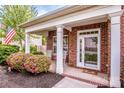 Inviting front porch with seating, flowers, and a charming entrance to the brick home at 219 Pleasant Grove Ln, Mooresville, NC 28115