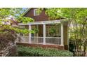 Charming front porch with white railings, brick foundation, and decorative hanging plants at 2306 Club Rd, Charlotte, NC 28205