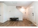 Bright living room with hardwood floors, a staircase, and a white door at 3033 Green Apple Dr, Dallas, NC 28034