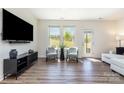 Bright living room with hardwood floors, stylish seating, and large windows offering natural light and outdoor views at 314 Embers Ln, Clover, SC 29710