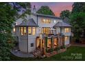 Lush backyard showing the house's stone columned covered patio, second story deck, and garden space at 3933 Ayrshire Pl, Charlotte, NC 28210