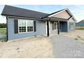 A stylish single-story home boasts gray siding, dark shutters, and a well-maintained gravel yard at 4044 Hurley Walters Rd, Lancaster, SC 29720