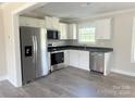 This kitchen features stainless steel appliances, white cabinets, and dark countertops, providing a modern aesthetic at 4044 Hurley Walters Rd, Lancaster, SC 29720