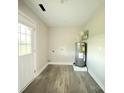 Utility room features a new water heater, wood-style flooring, and access door to backyard at 4044 Hurley Walters Rd, Lancaster, SC 29720
