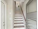 Bright entryway staircase with wood and white risers leads up to the next level of the home at 520 Sedgefield Park Dr, Charlotte, NC 28203