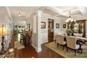 Open-concept dining room with elegant chandelier, decorative moldings, and hardwood floors at 79115 Ridgehaven Rd, Lancaster, SC 29720
