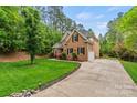 Beautiful home with well-maintained lawn, long driveway, and attached garage at 8032 Turnberry Ln, Stanley, NC 28164