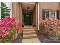 Inviting front entrance with blooming flowers and brick steps at 8032 Turnberry Ln, Stanley, NC 28164