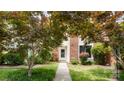 Charming brick home with inviting walkway, lush landscaping, and a pristine white front door at 8326 Ramath Dr, Charlotte, NC 28211